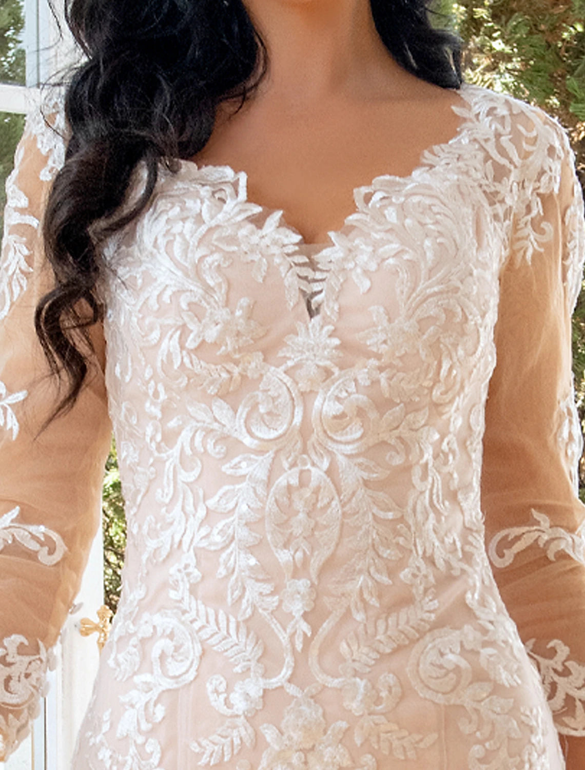 Full length view of a mermaid trumpet wedding dress with intricate lace details.