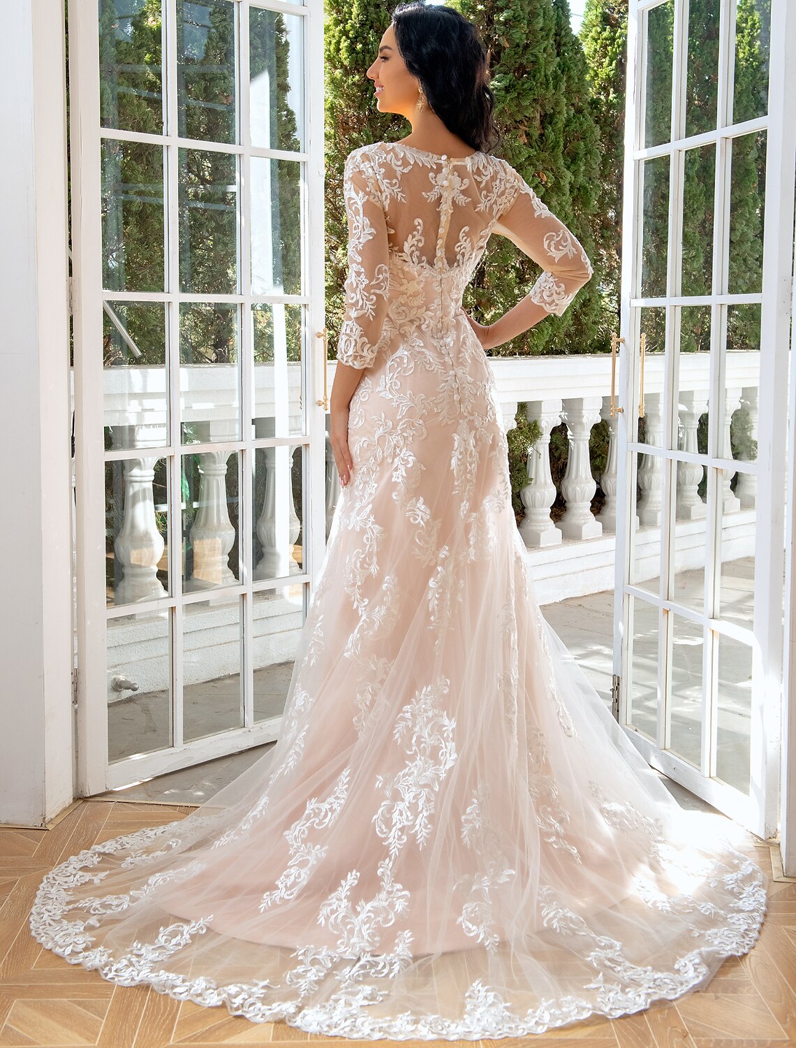 Back view of a mermaid bridal gown with sweep train and lace appliques.