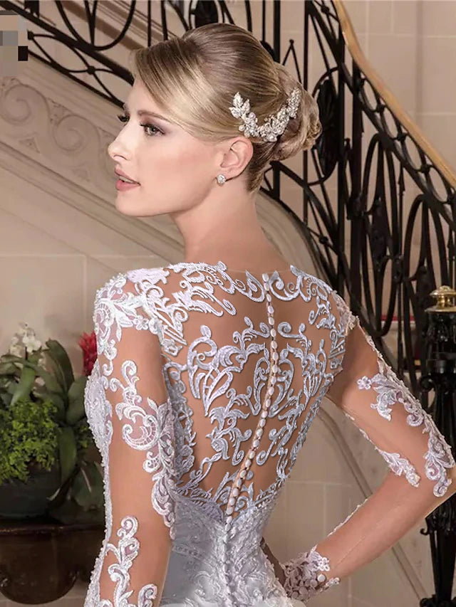 Close-up of the lace and beading on a long sleeve wedding dress.