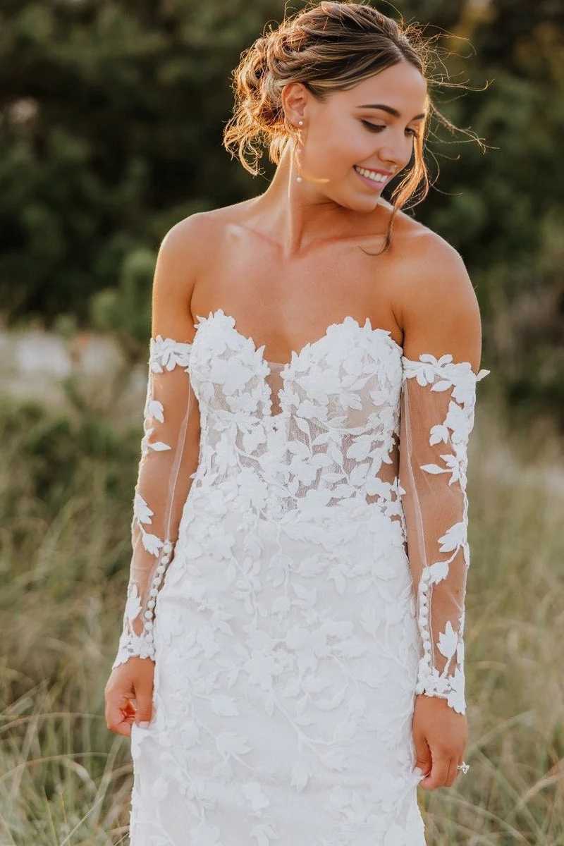 Elegant mermaid wedding dress with sweetheart neckline, long illusion sleeves, and delicate appliques.