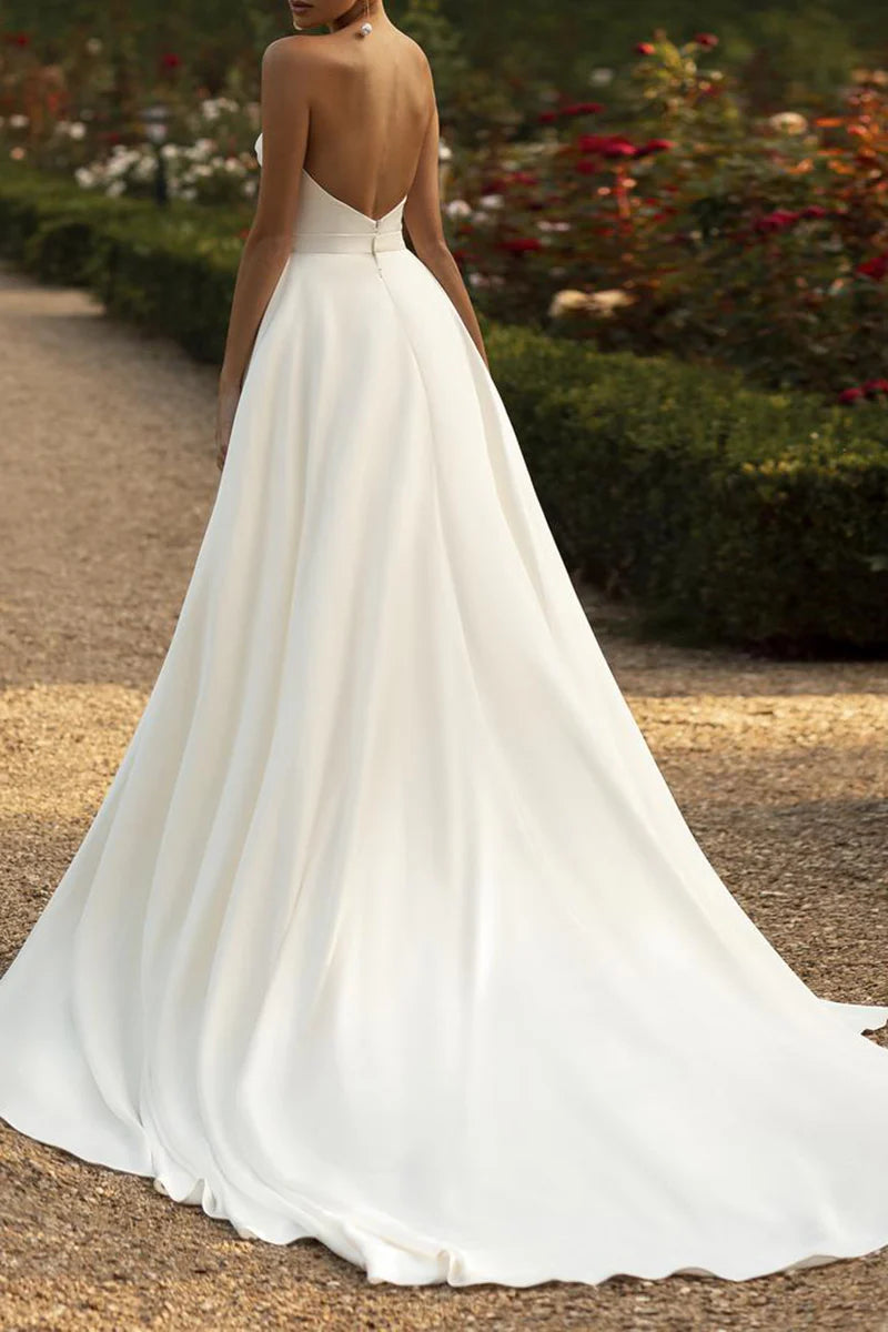 Back view of a bride in a white mermaid satin wedding gown.