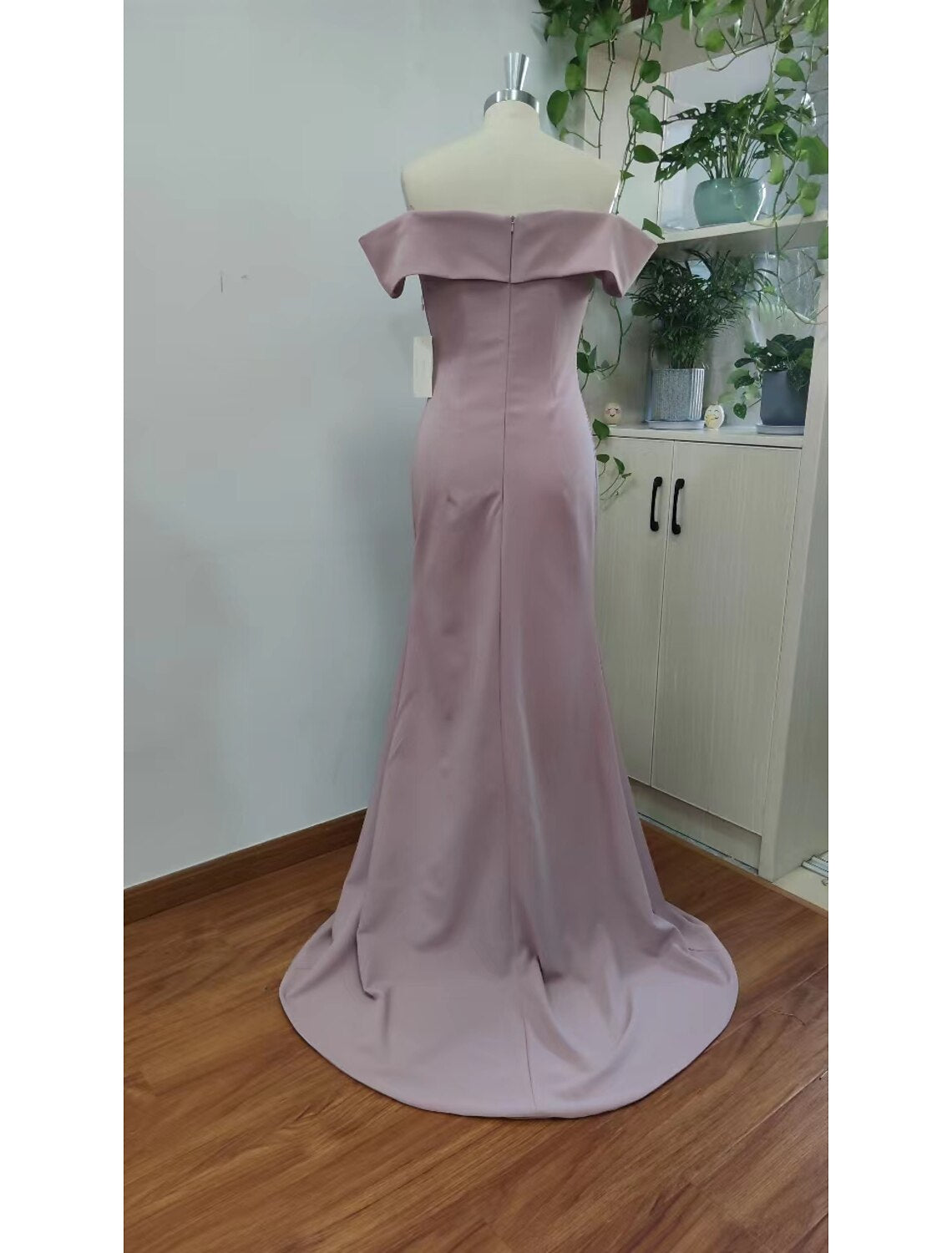 Side view of a floor-length chiffon mermaid dress with a slit.