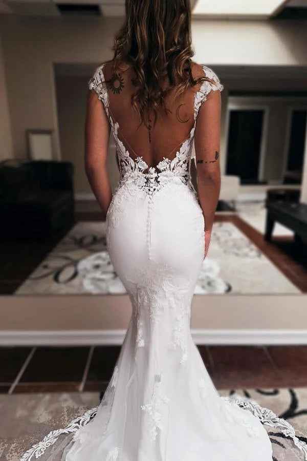 Side view of the mermaid silhouette and chapel train of the wedding dress.