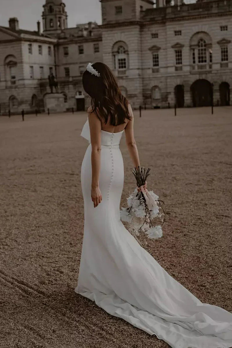 Back view of a white satin mermaid wedding dress.