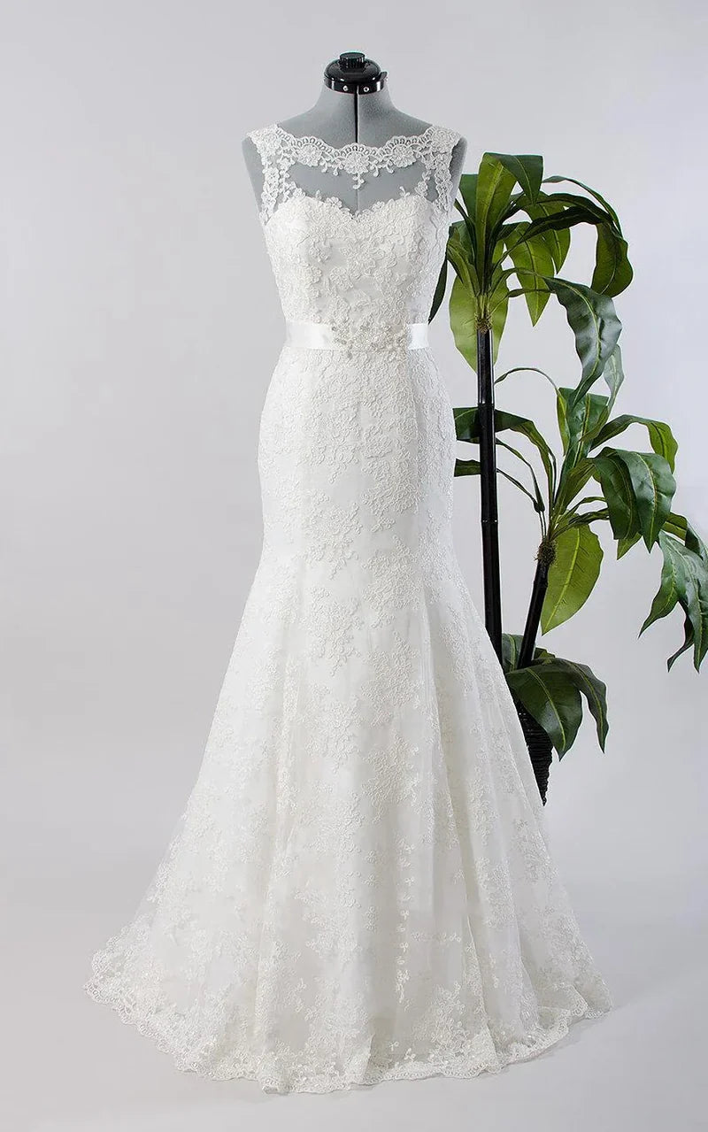 Woman wearing an elegant sleeveless mermaid gown with sweetheart neckline, made of tulle, lace, and satin.