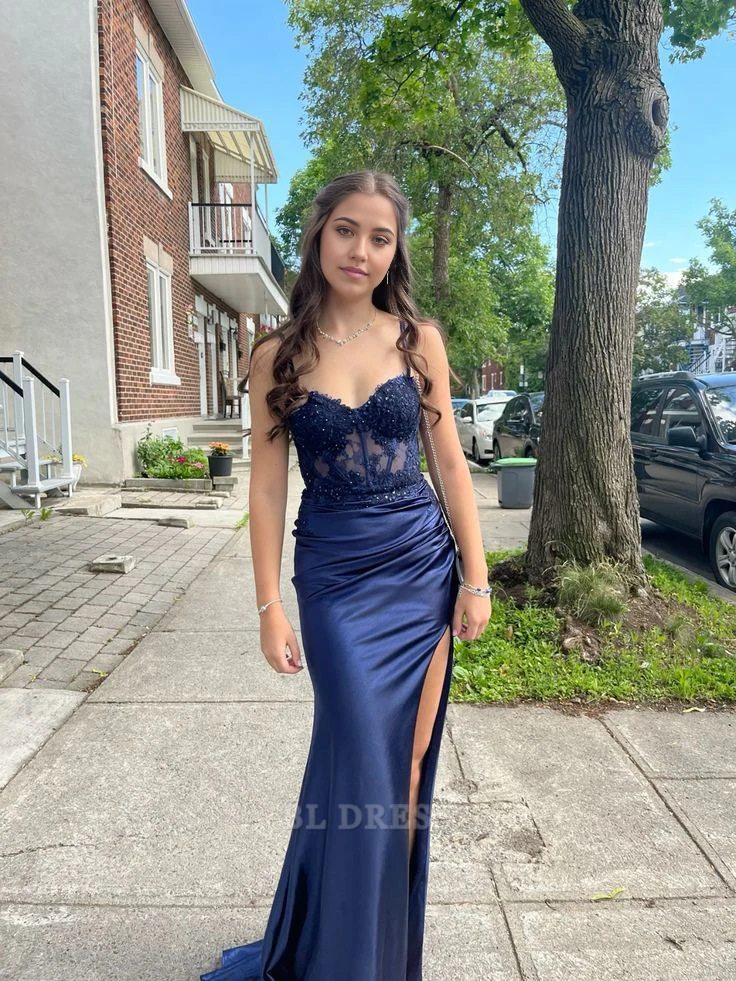 Woman wearing a navy blue mermaid formal dress with sweetheart neckline, spaghetti straps, and applique details.