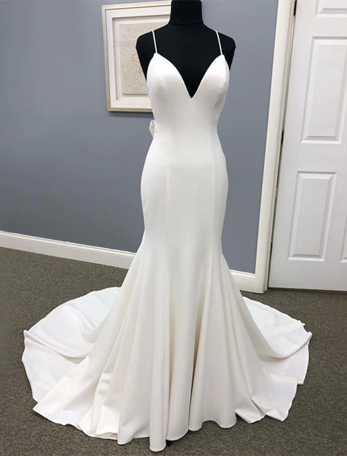 Elegant mermaid wedding dress with sweetheart neckline and spaghetti straps, featuring a court train and bows.