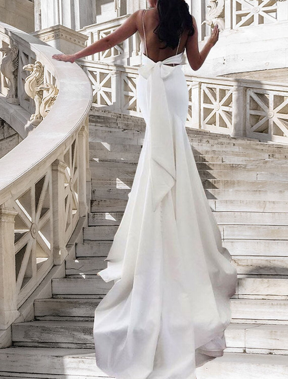Satin mermaid wedding dress with delicate spaghetti straps and a subtle sheen.