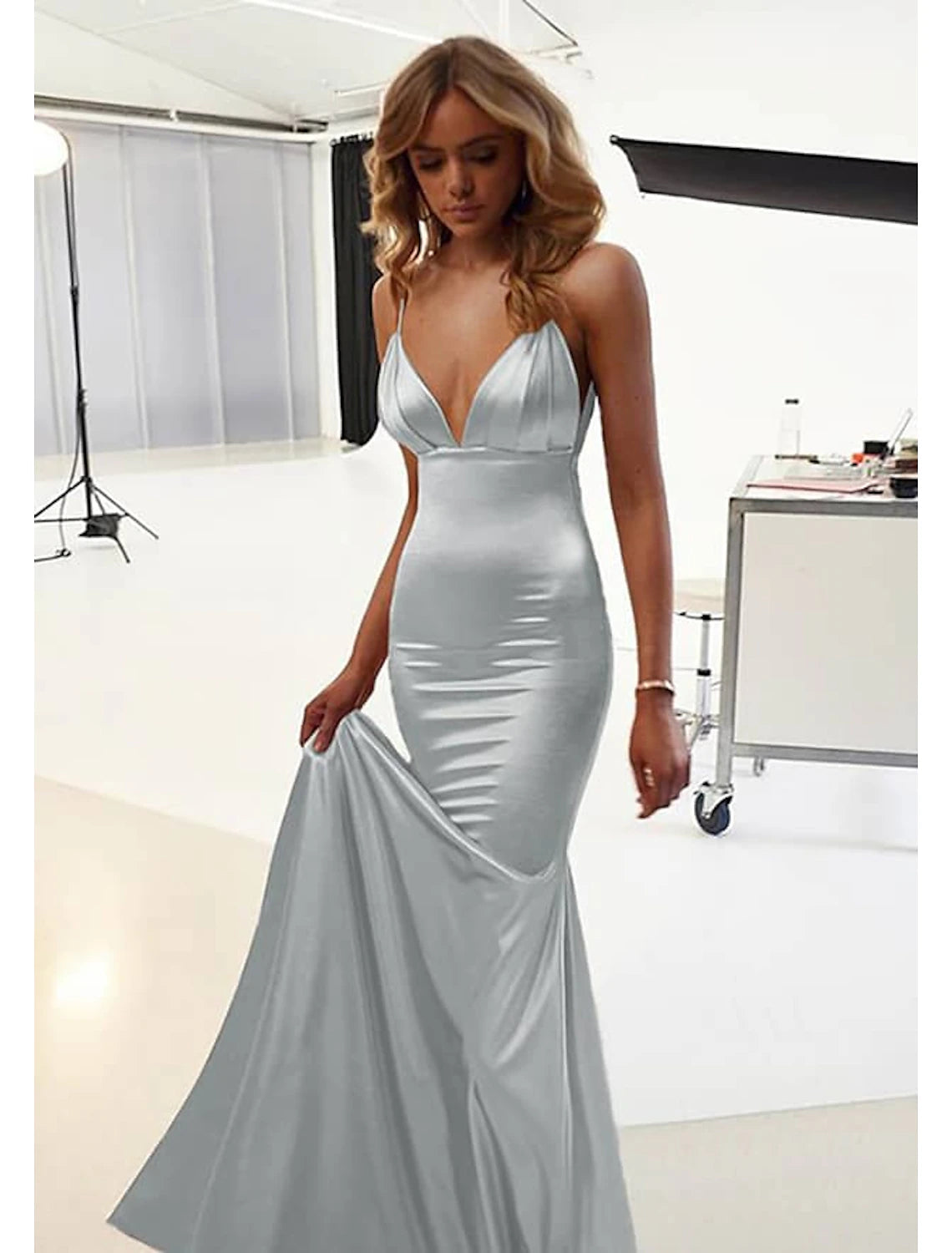 Model wearing a sophisticated blue mermaid trumpet backless ruched floor-length dress.