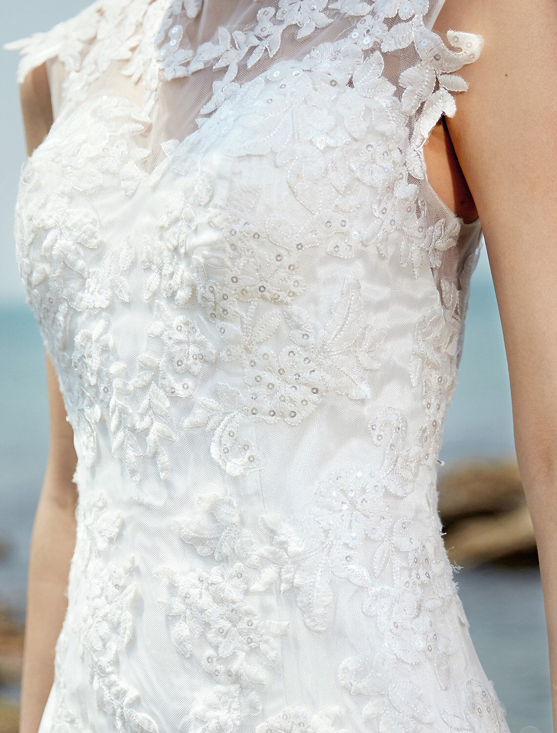 Close-up of the bateau neck and ruched bodice on a wedding gown.
