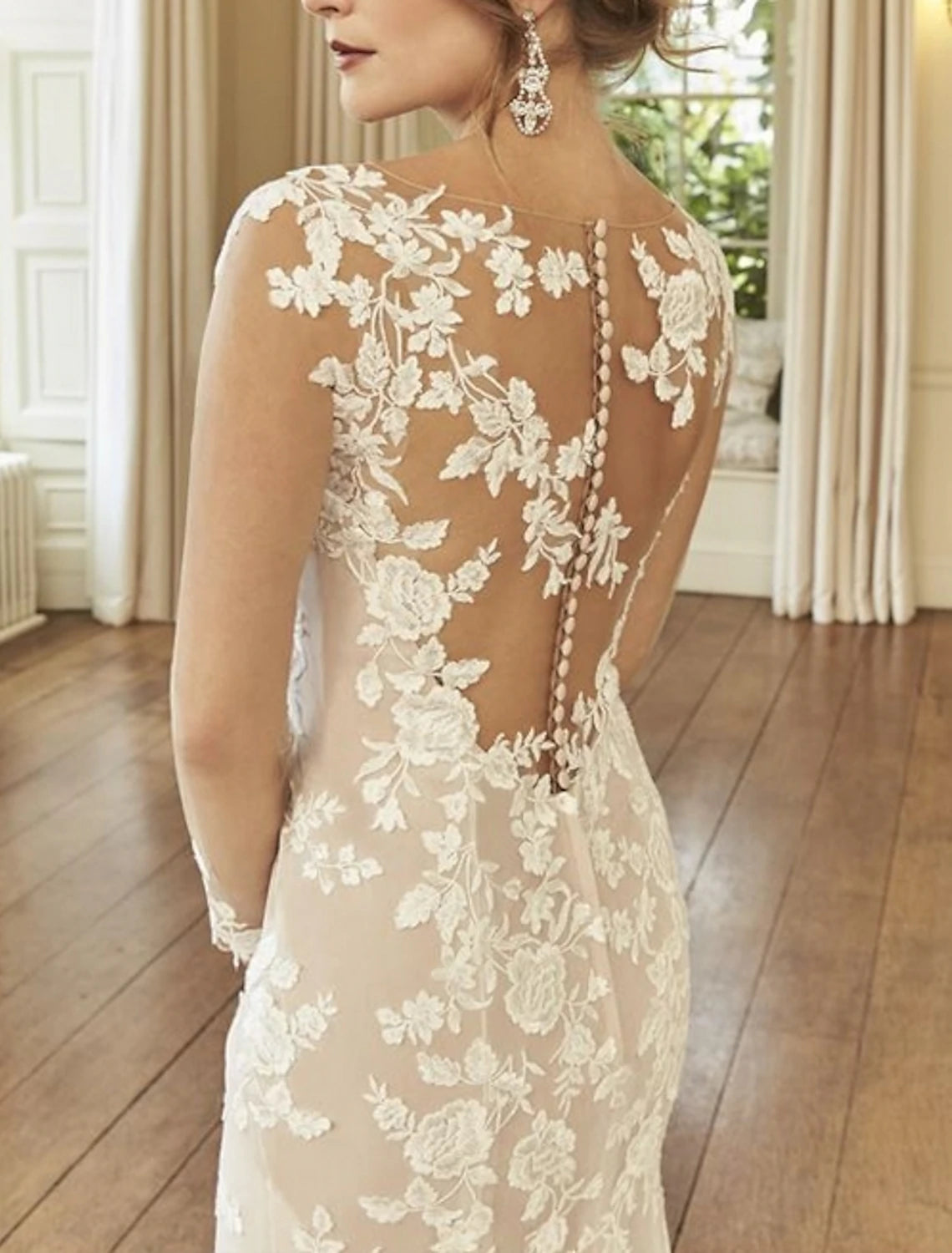 Close-up of illusion neck and long sleeve lace embroidery on bridal gown.