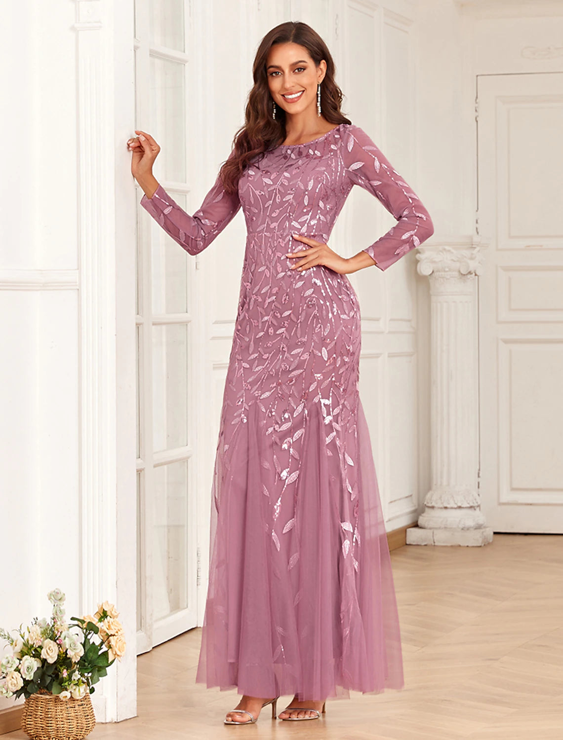 Back view of an elegant woman in a floor length embroidered tulle evening gown.