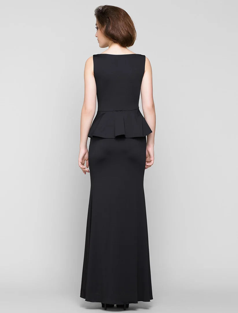 Side view of a woman in a sleeveless navy mermaid trumpet dress with pleated details.