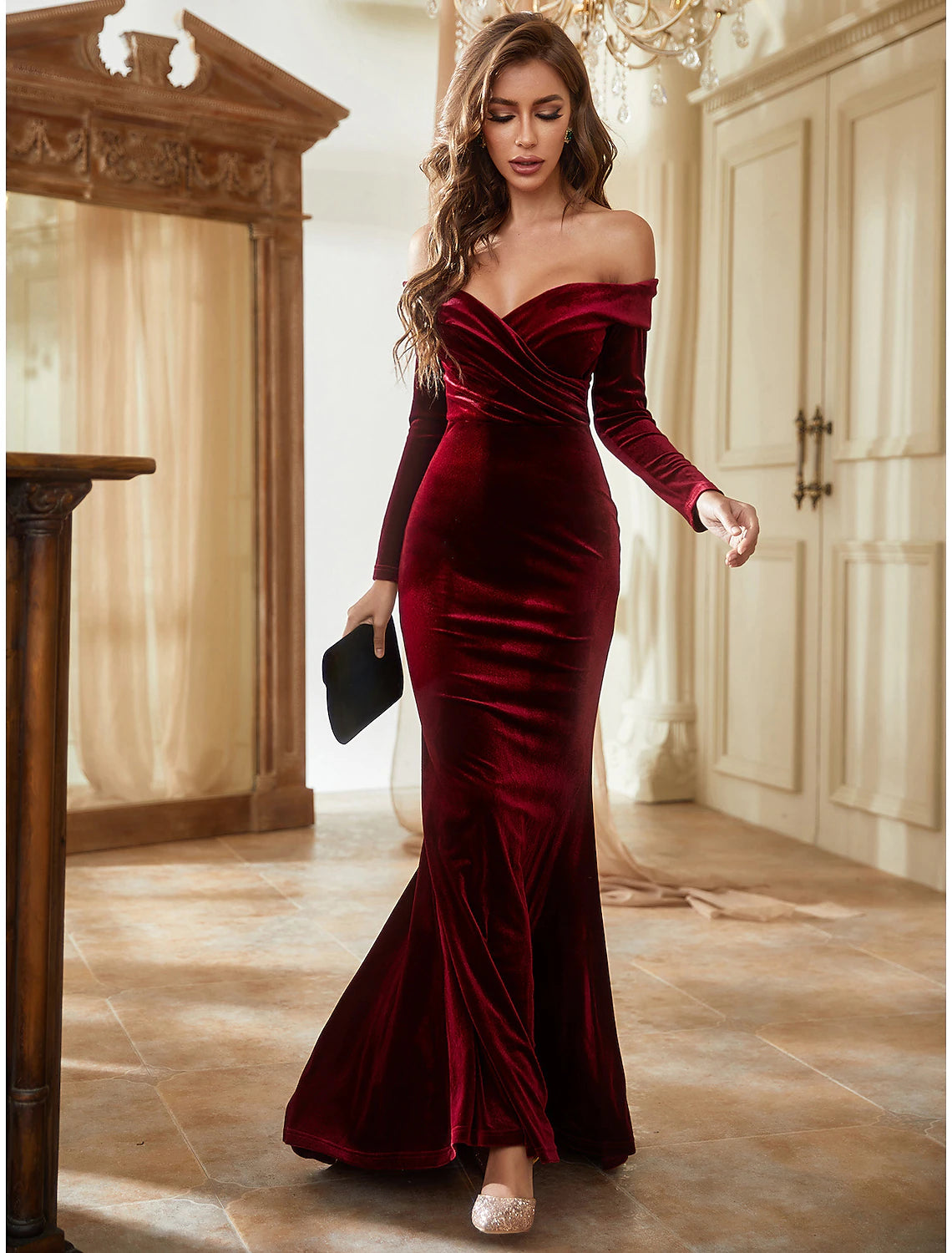 Elegant velvet mermaid trumpet gown with off-shoulder neckline and long sleeves.