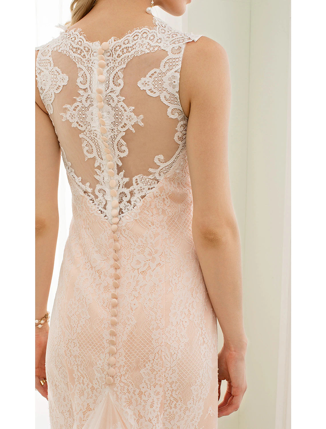 Close-up of lace appliques and button detailing on a bridal gown.