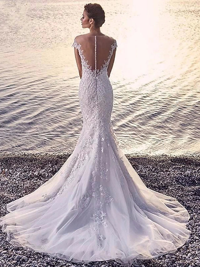 Full view of a mermaid trumpet wedding gown, showcasing its court train and intricate appliques.