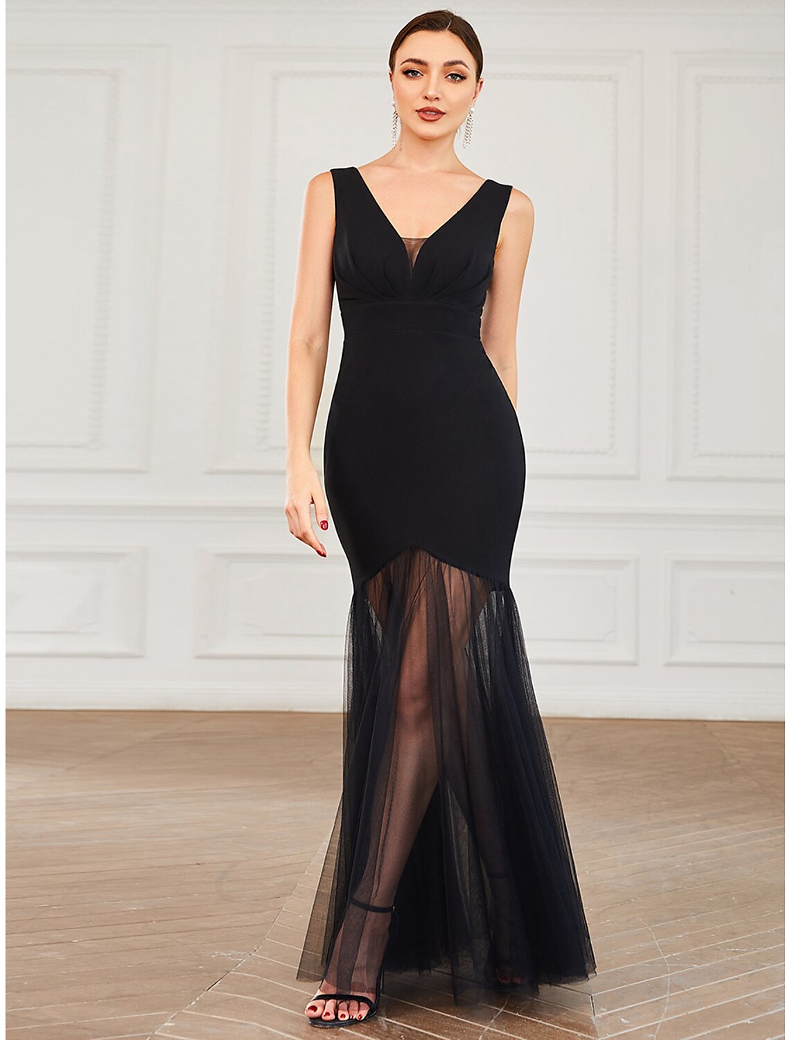 Woman wearing an elegant black mermaid trumpet evening gown with a V-neck.