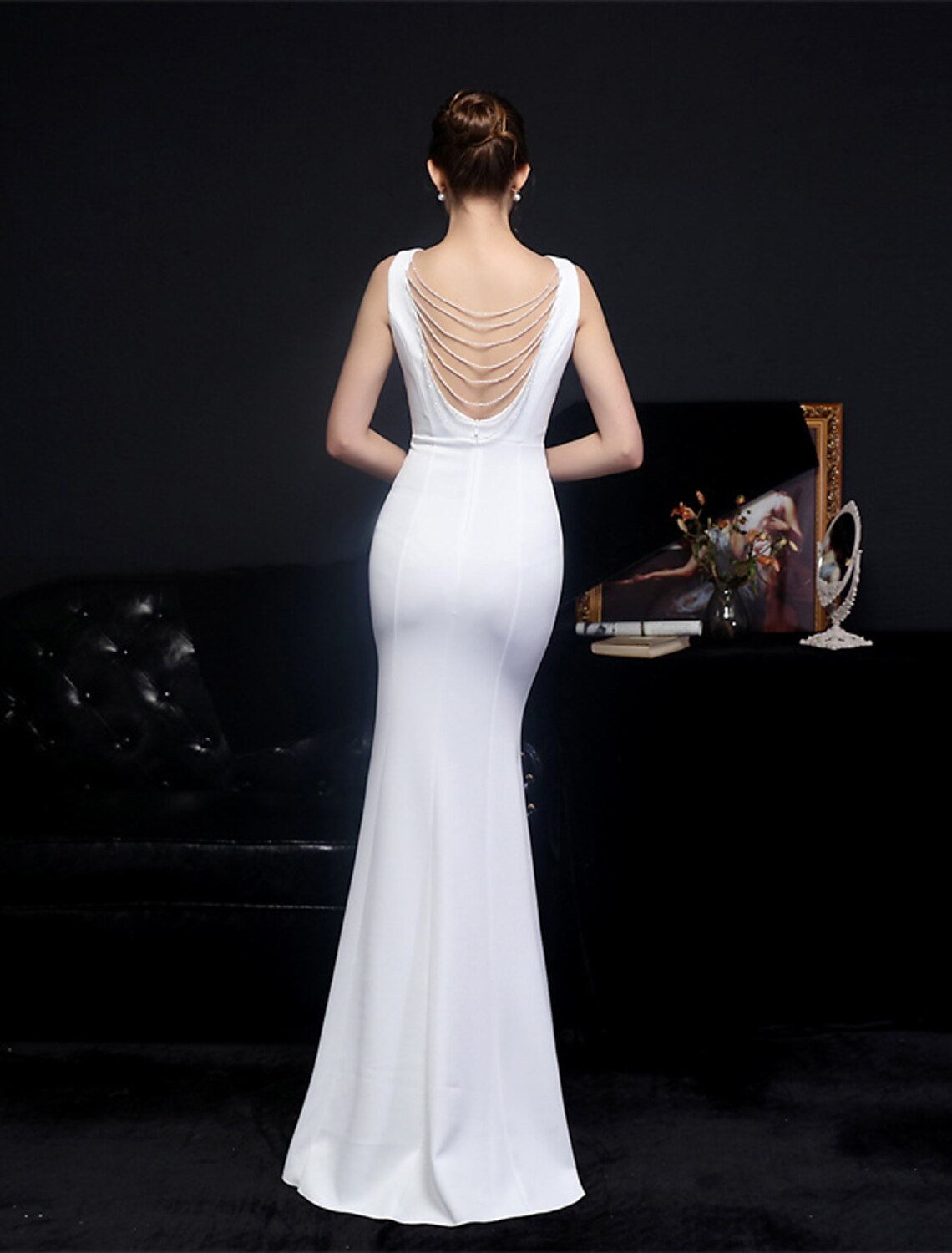 Back view of a woman in a floor-length formal mermaid gown.