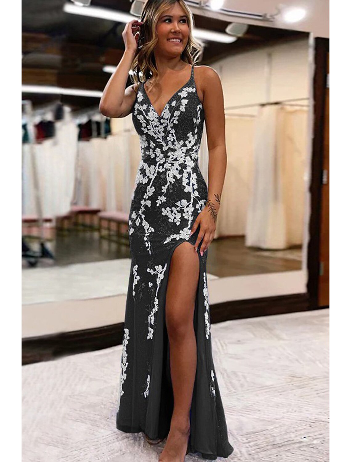 Back view of a backless mermaid trumpet prom dress with intricate appliques.