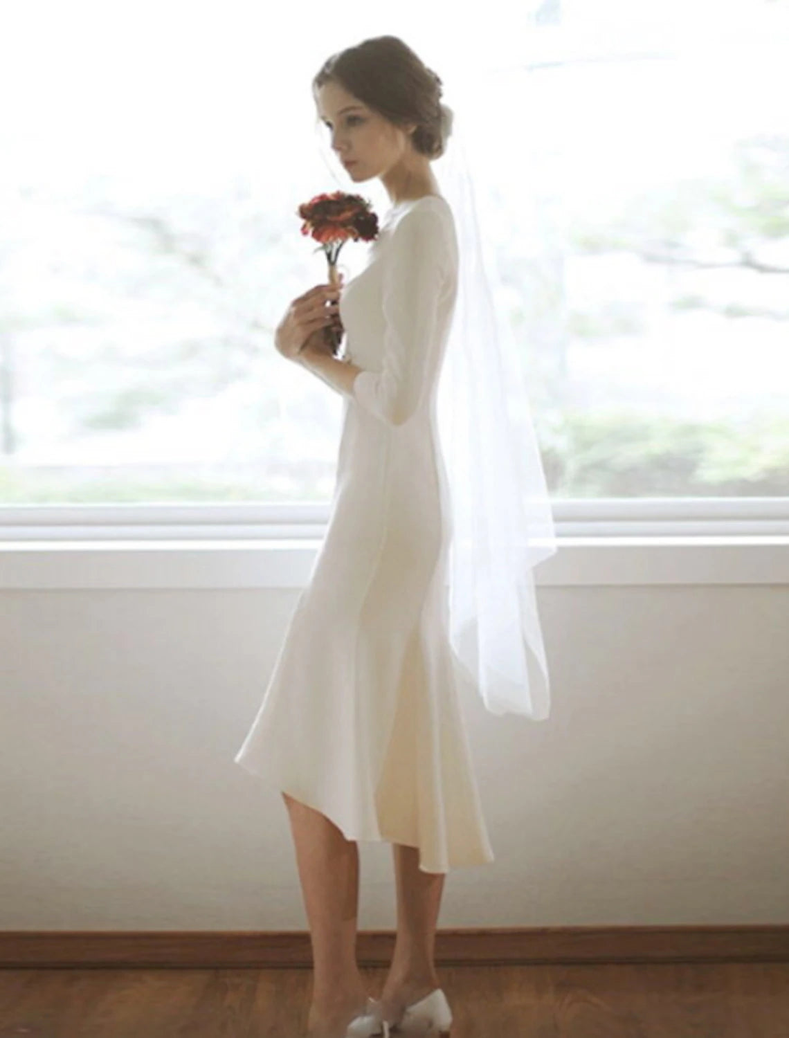 Back view of the white mermaid wedding dress with 3/4 sleeves.