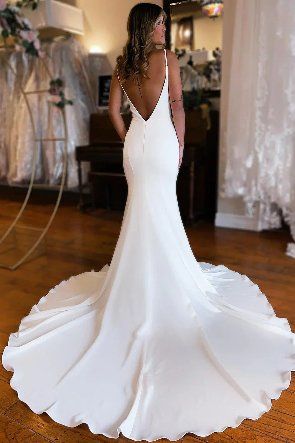 Back view of the white mermaid wedding gown, highlighting the open back.