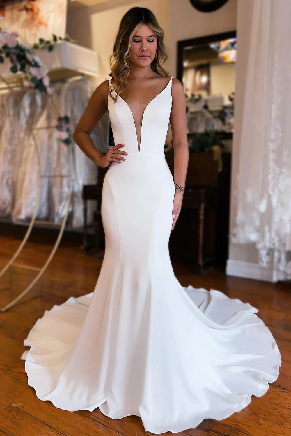 White mermaid wedding dress with a backless design and V-neckline.