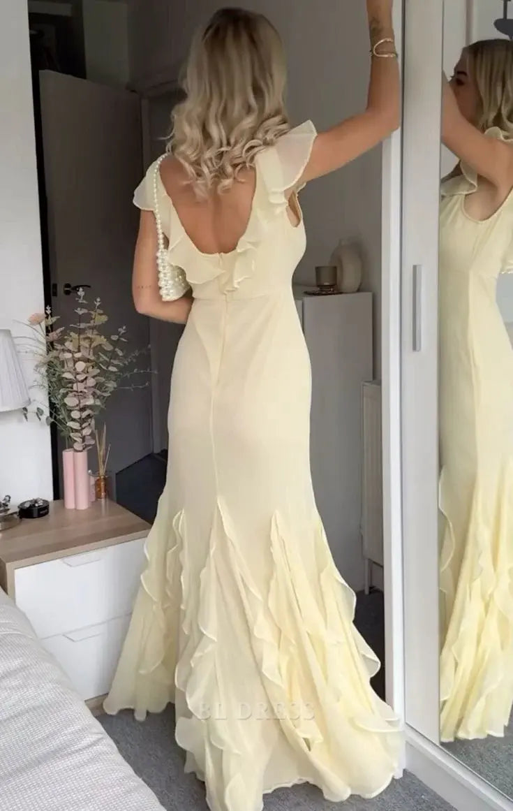 Woman posing gracefully in a flowing mermaid V-neck backless chiffon dress.