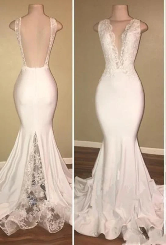Woman wearing an elegant white mermaid V-neck backless lace prom dress.