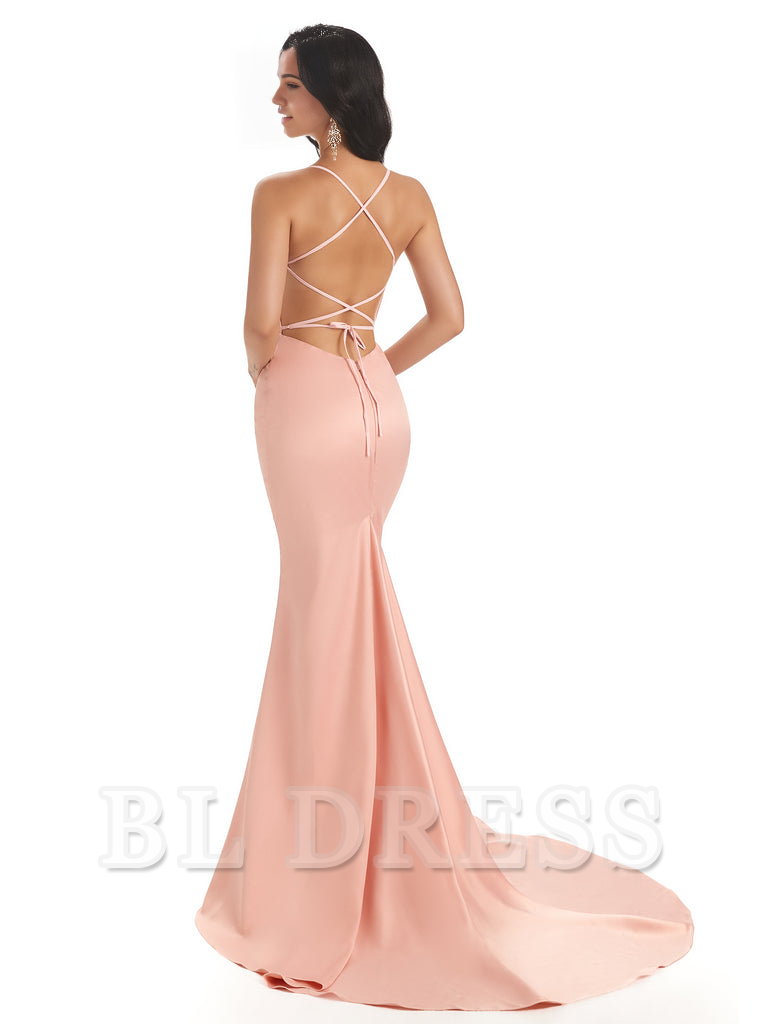 Side view of a woman in a long backless satin mermaid gown.