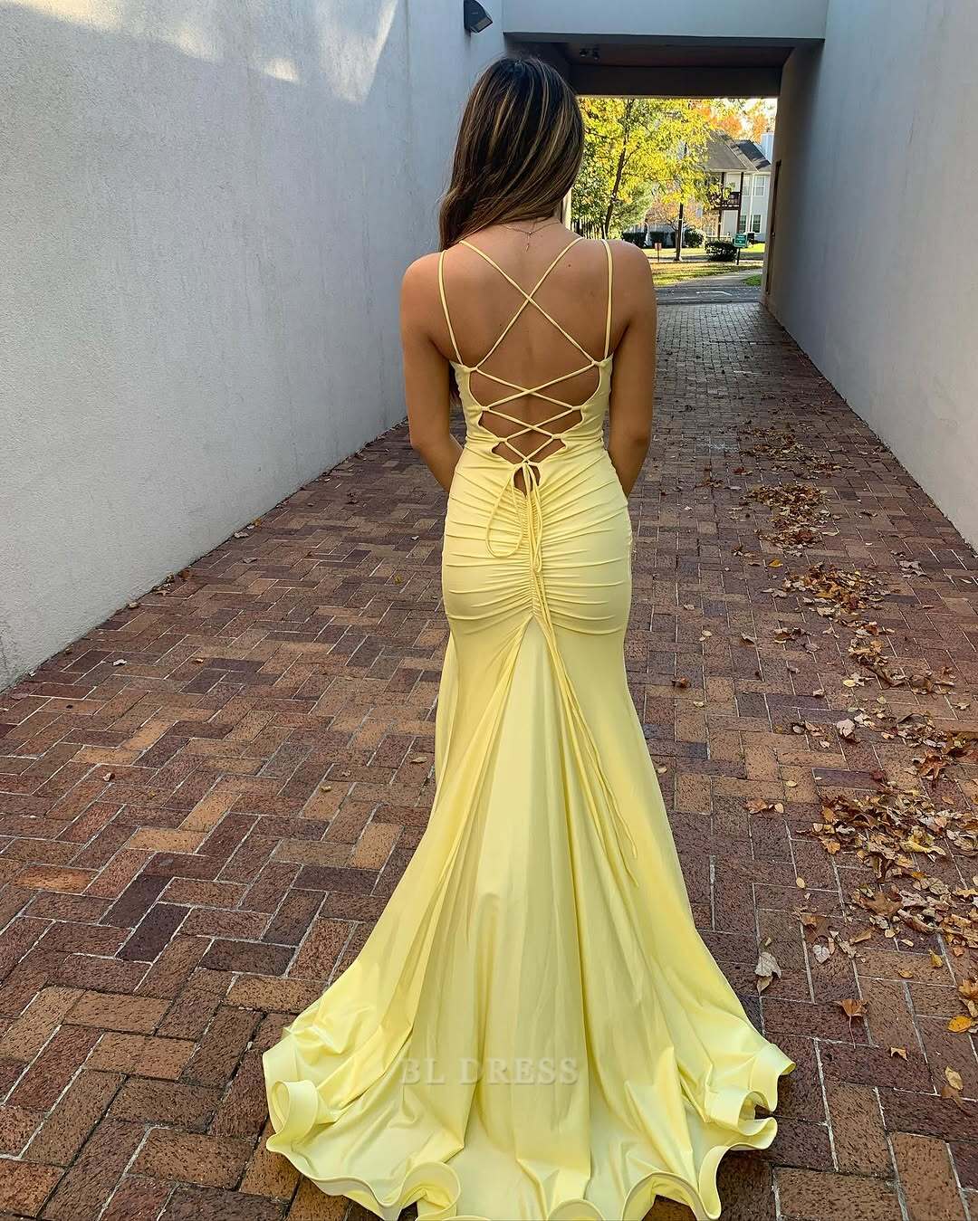 Full view of a long yellow mermaid prom dress.