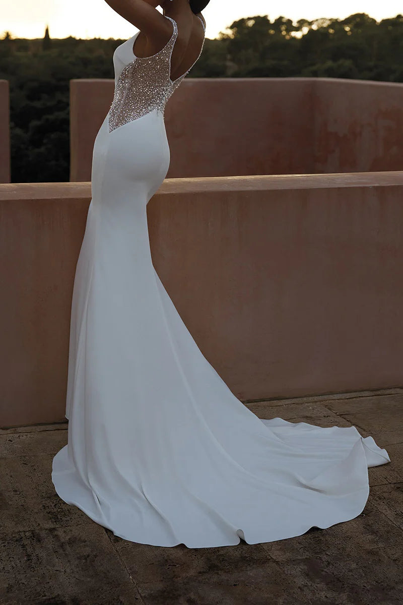 Close-up of the V-neckline and beaded details on a wedding dress.
