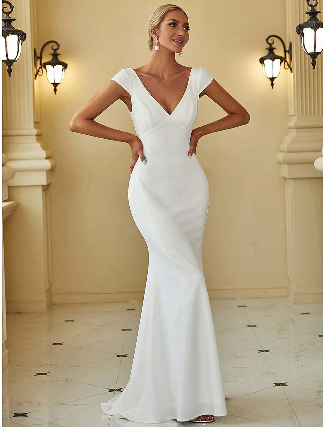 Back view of a woman in a white mermaid wedding dress with a sweep train.