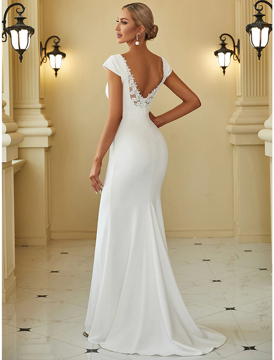 Close-up of the draped detail on a white stretch fabric wedding dress.