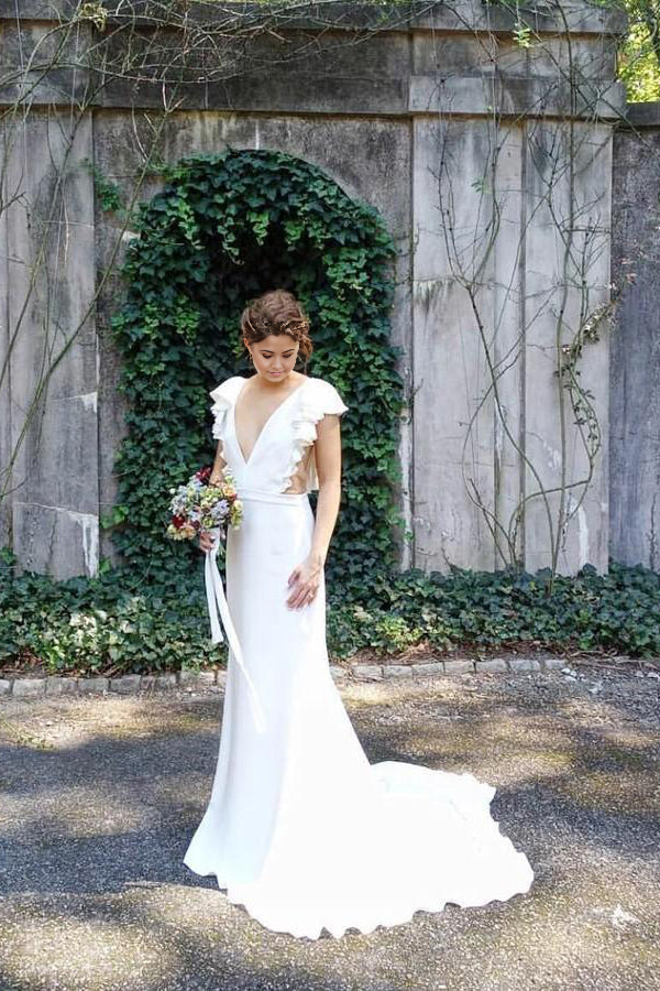 Elegant mermaid wedding dress with V-neck, cap sleeves, and ruffled skirt.