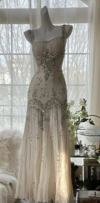 Woman wearing a white chiffon mermaid prom dress, front view.