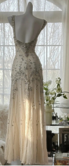 Side view of a woman in a white mermaid V-neck gown.