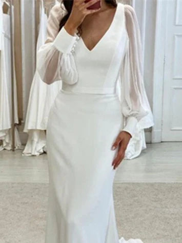Close-up of the V-neckline and long sleeves on a mermaid wedding gown.