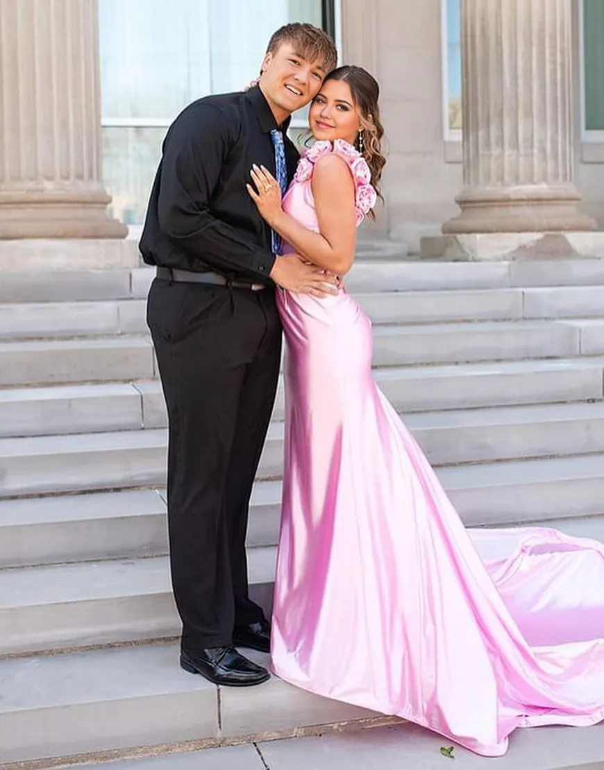 Close-up of the V-neckline and floral embellishments on the pink satin dress.
