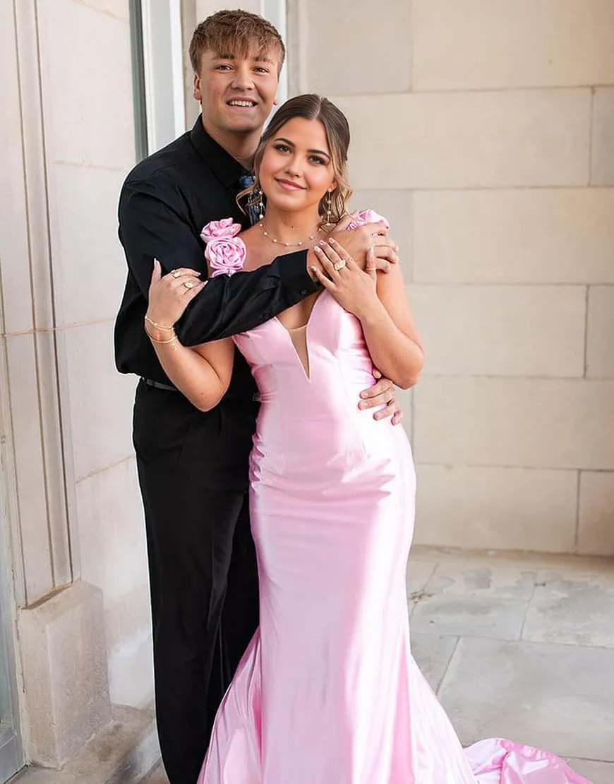 Detail shot of the luxurious satin fabric and floral appliques on the pink mermaid gown.