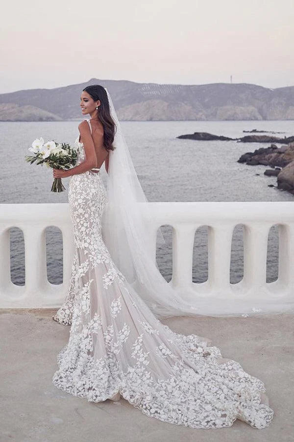 Elegant mermaid wedding dress with lace straps and intricate appliques.