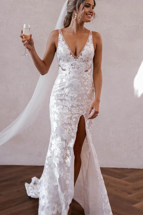 Full length view of a mermaid V-neck lace boho wedding dress with a flowing skirt and slit.
