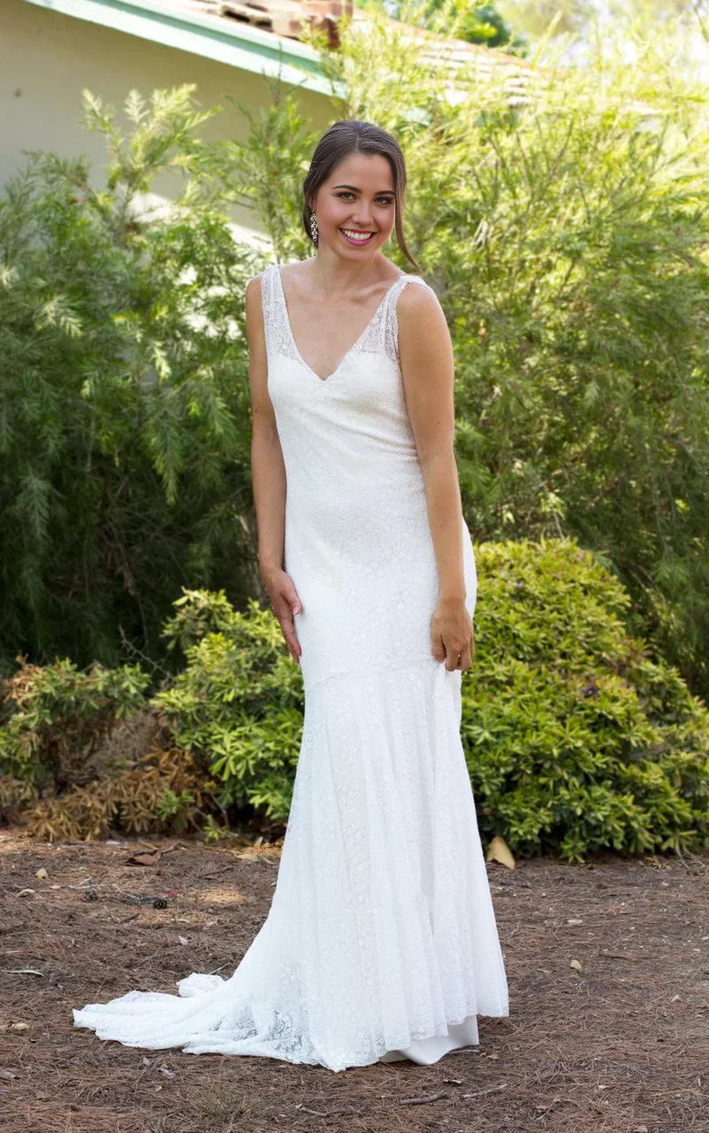 Elegant mermaid lace wedding dress with V-neck and low back.