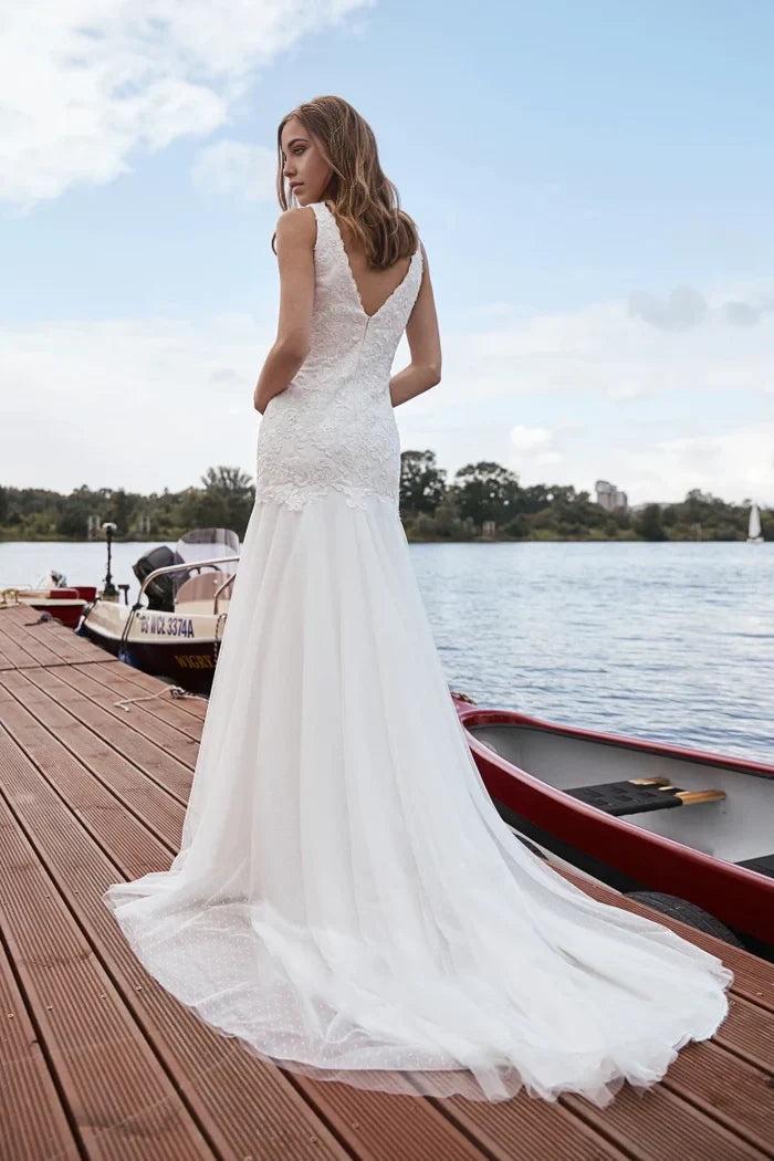 Back view of a mermaid wedding gown featuring a lace V-neck and long tulle train.