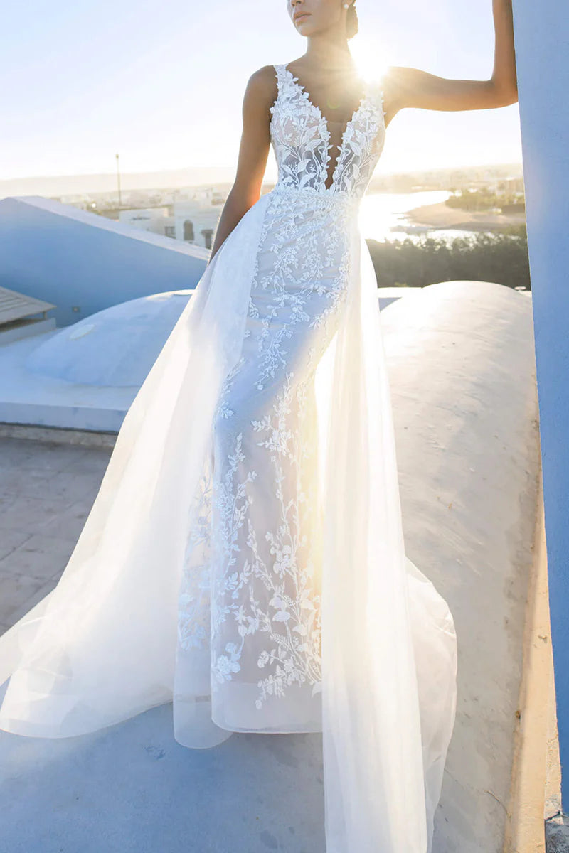 Back view of the mermaid V-neck lace wedding dress with a flowing train.