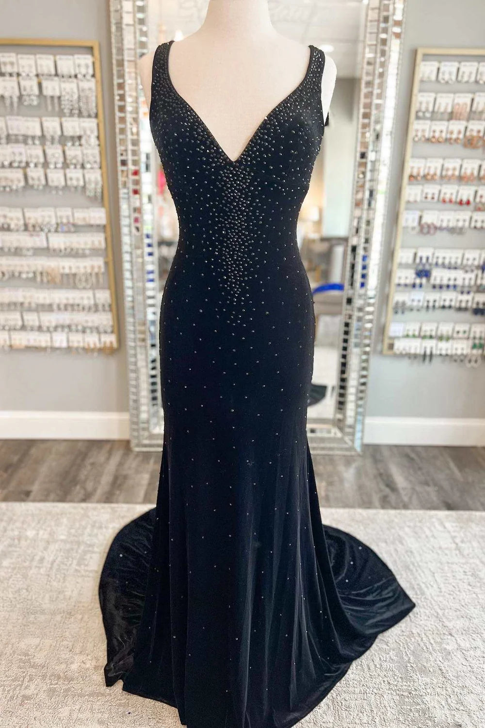 Side profile of a model in a mermaid V-neck long prom dress.