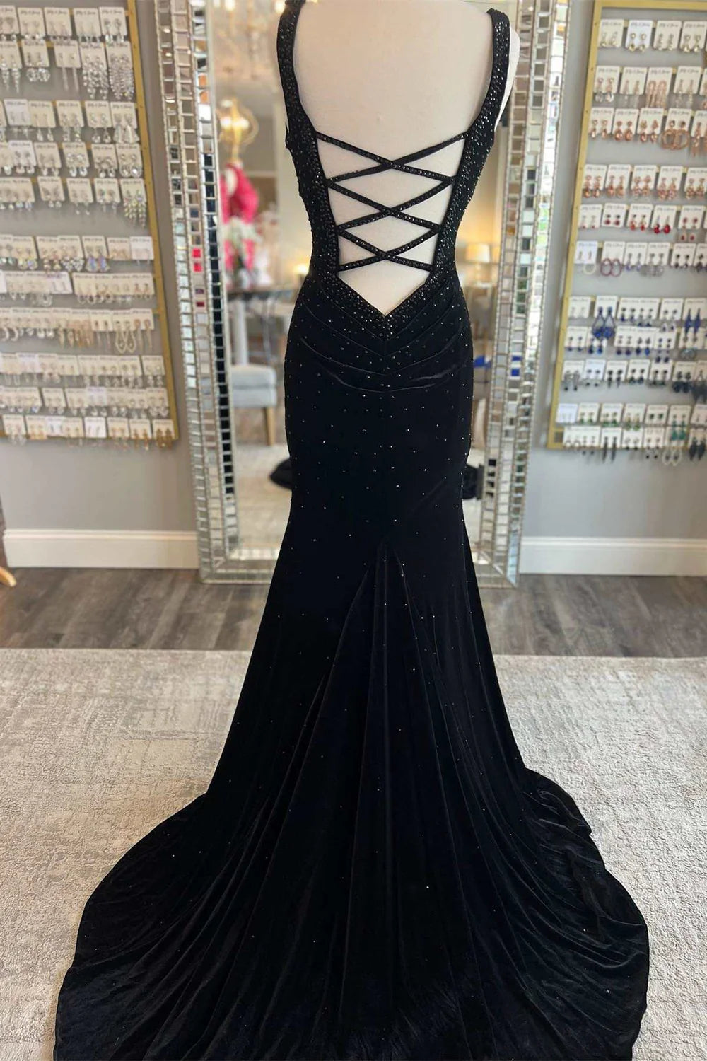 Full length view of a model posing gracefully in a mermaid V-neck prom dress.