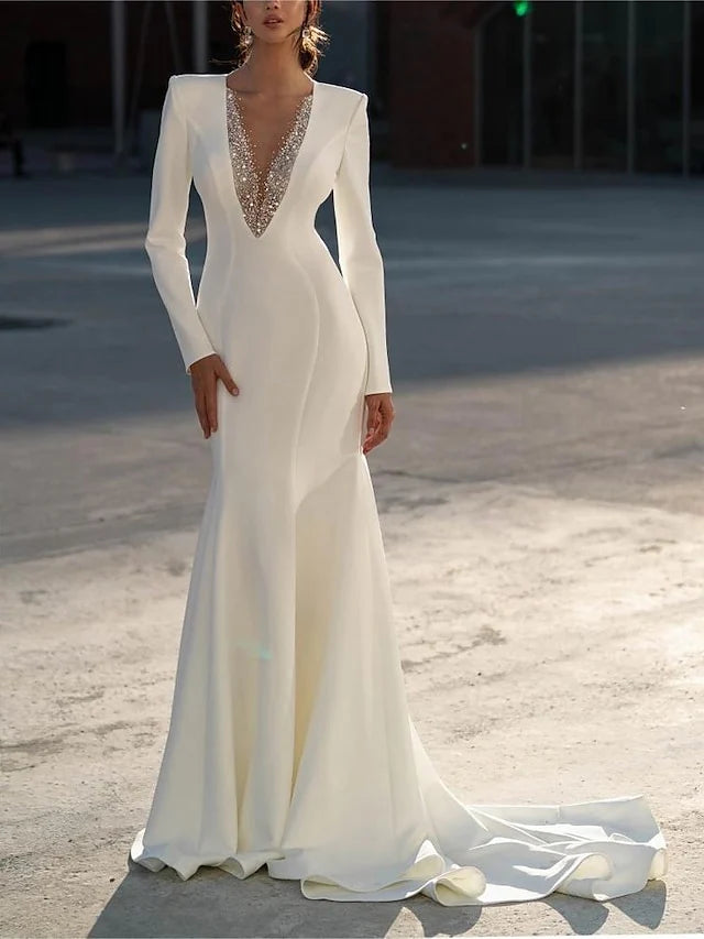Model wearing a white mermaid V-neck long sleeve wedding dress, front view.