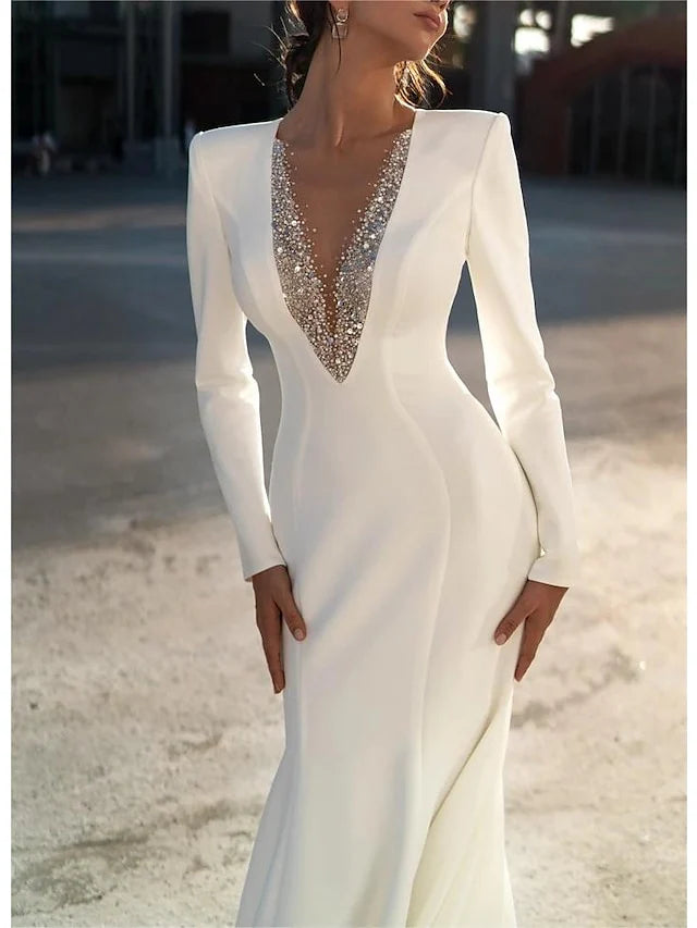 Side profile of a model showcasing a white mermaid V-neck long sleeve wedding dress.