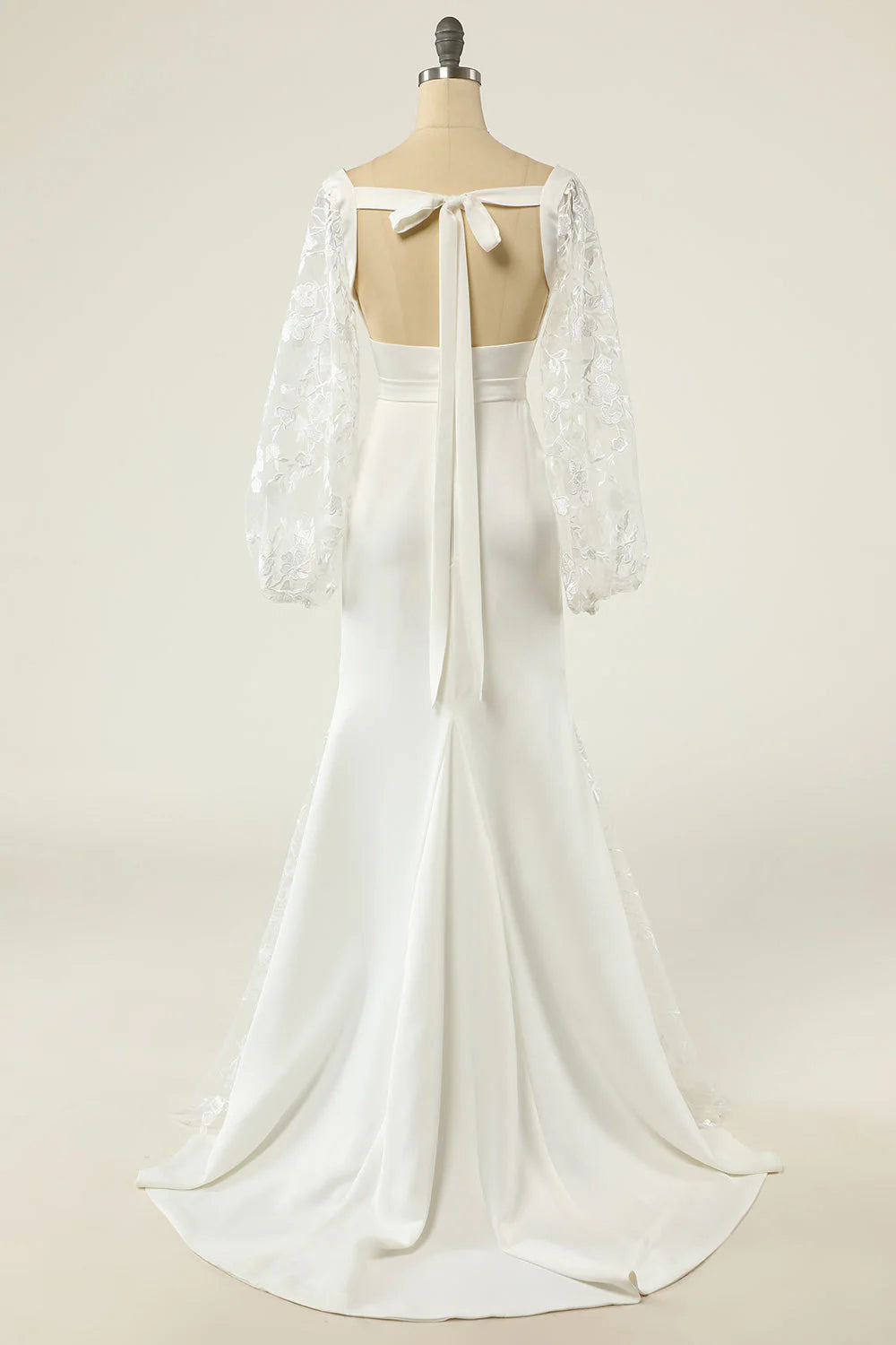 Side view of a mermaid wedding gown with long sleeves and train.