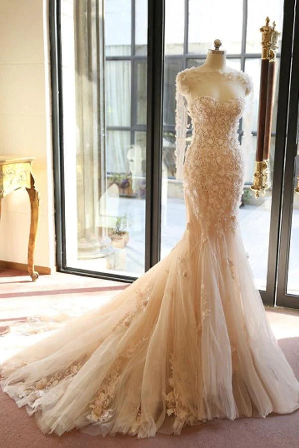 Close-up of the sheer floral long sleeves and open back of the mermaid wedding dress.